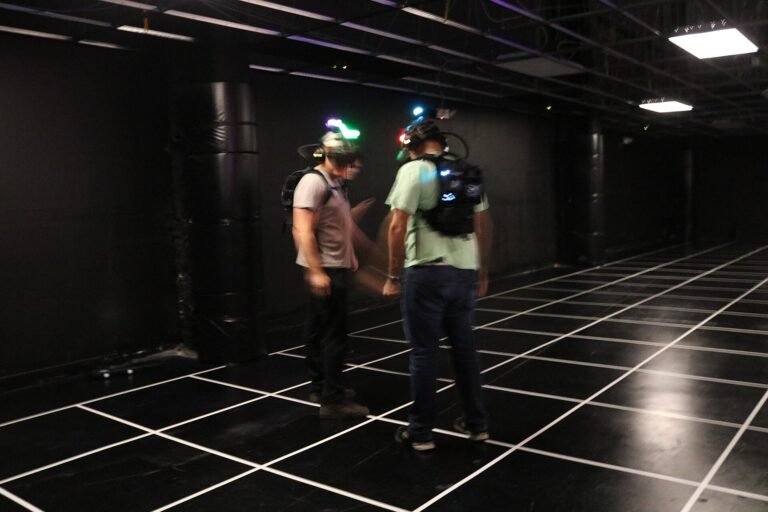 Gruppe mit VR-Brillen und Controllern auf einer gemeinsamen Spielfläche